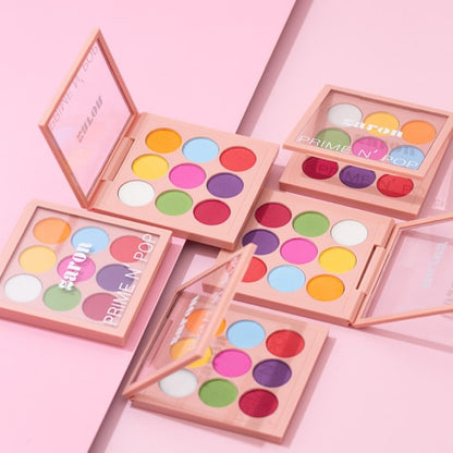Colorful makeup palettes with 'PRIME N POP' branding on a pink background