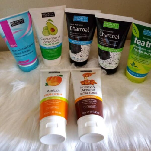 Collection of facial scrubs with various ingredients on a textured surface
