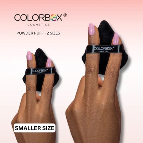 Colorbox Cosmetics powder puff on fingers with 'Smaller Size' label against a pink background
