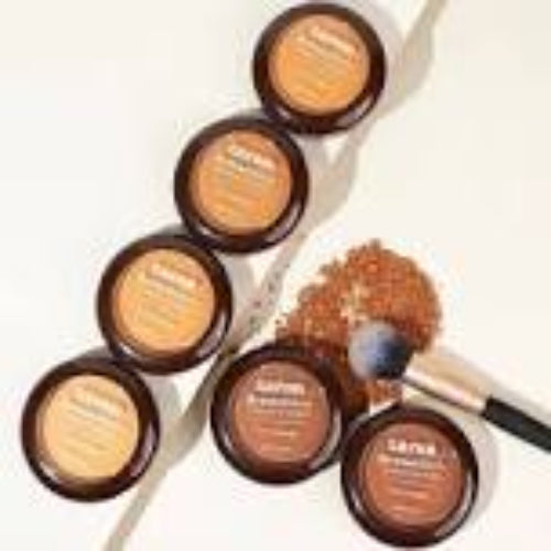 Set of skincare products with jars and a brush on a white background